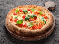 Домашна пица с италианско тесто, моцарела, чери домати и пресен босилек на плоча